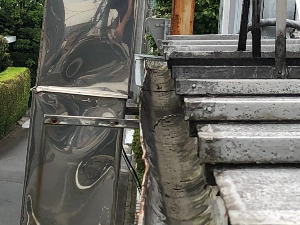 強風の影響により雨樋が大きく歪んでいる状態