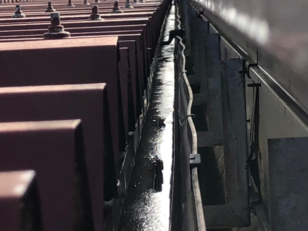 強風の影響により雨樋が大きく歪んでいる状態