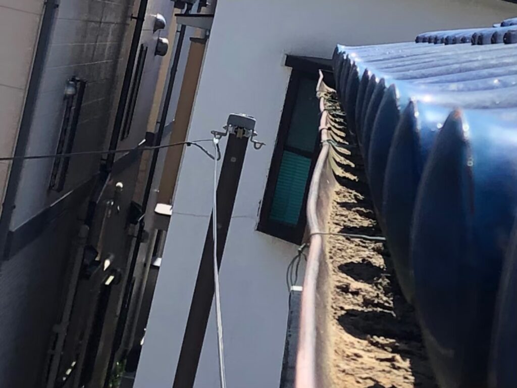 強風の影響により雨樋が大きく歪んでいる状態