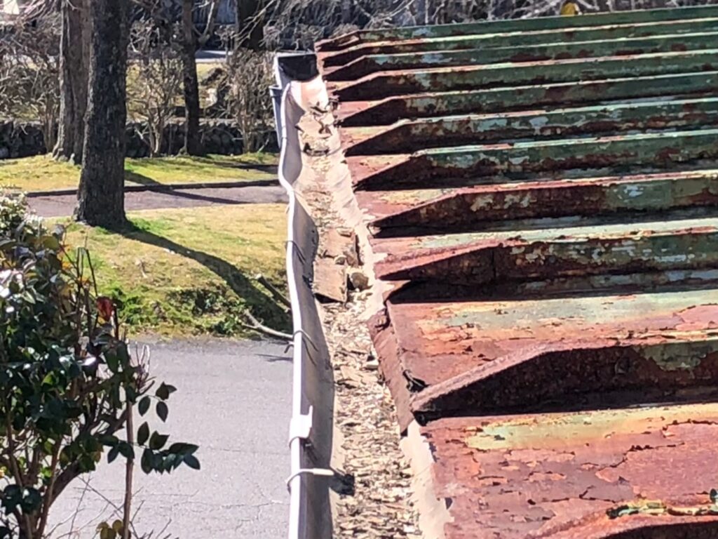 強風の影響により雨樋が大きく歪んでいる状態