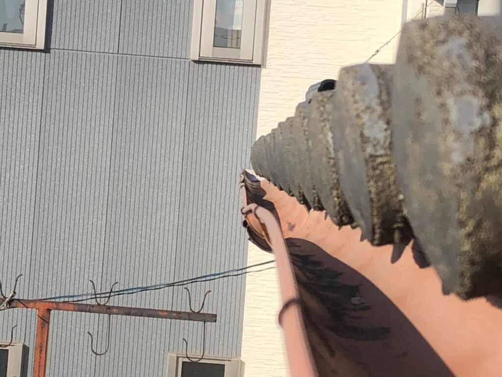 強風の影響により雨樋が大きく歪んでいる状態