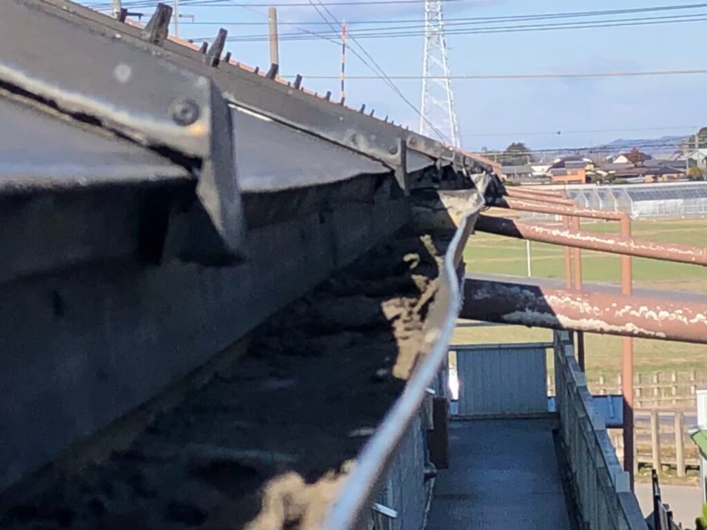 強風の影響により雨樋が大きく歪んでいる状態
