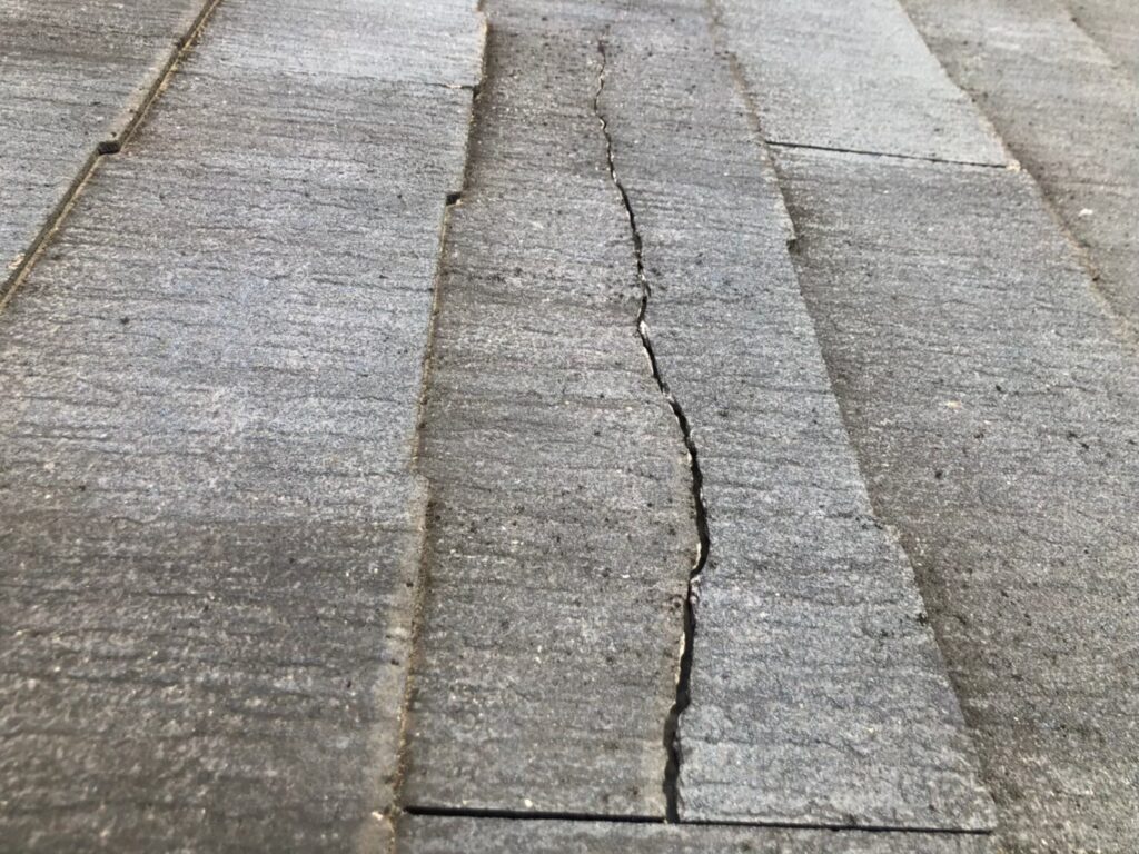 台風の影響によりスレート屋根にひび割れが生じた状態。