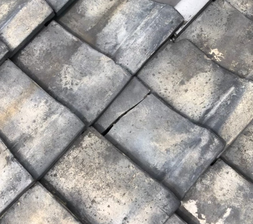 台風の影響により屋根材が割れている状態