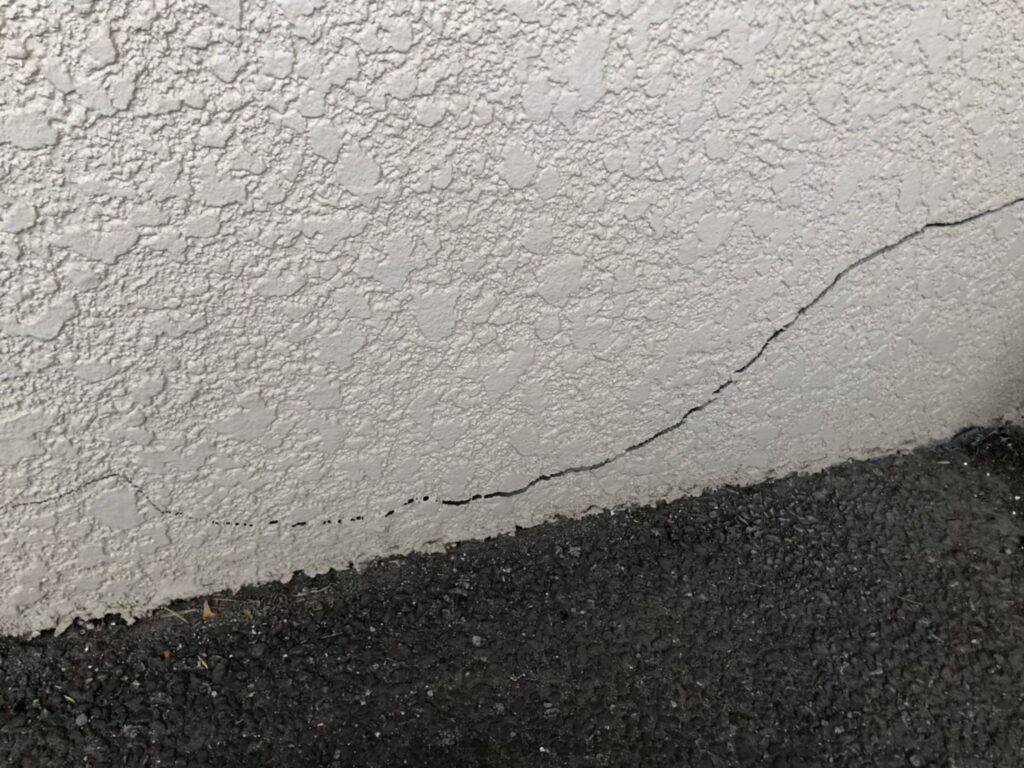 地震の影響により外壁表面がひび割れしている状態
