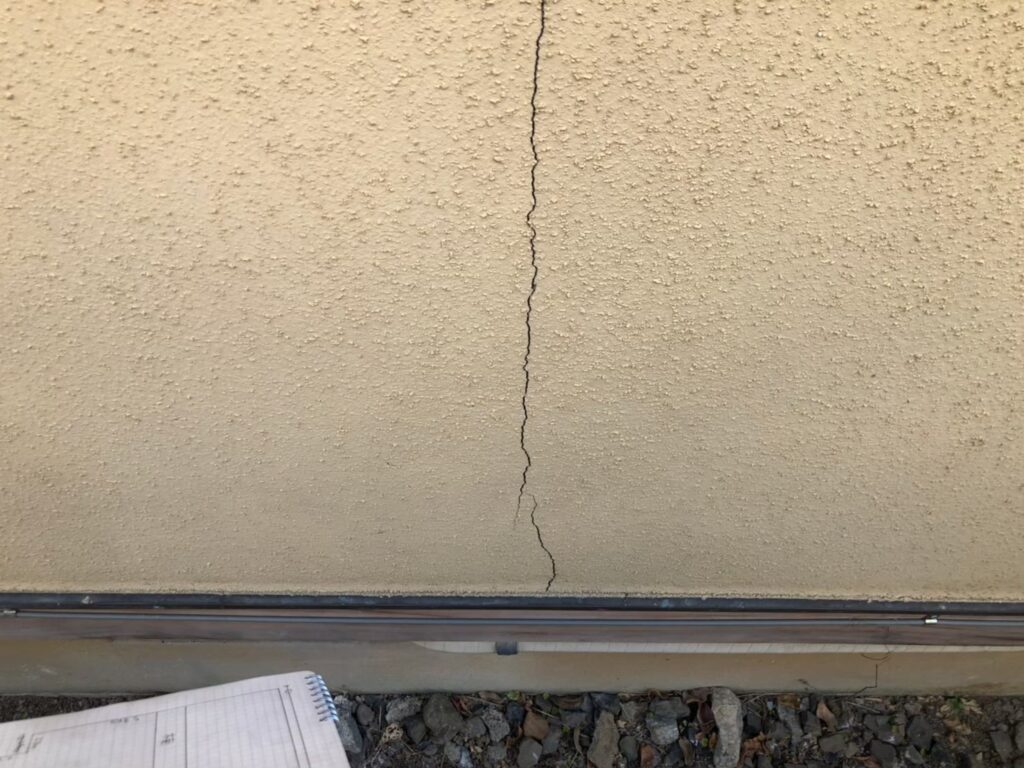 地震の影響により外壁表面がひび割れしている状態