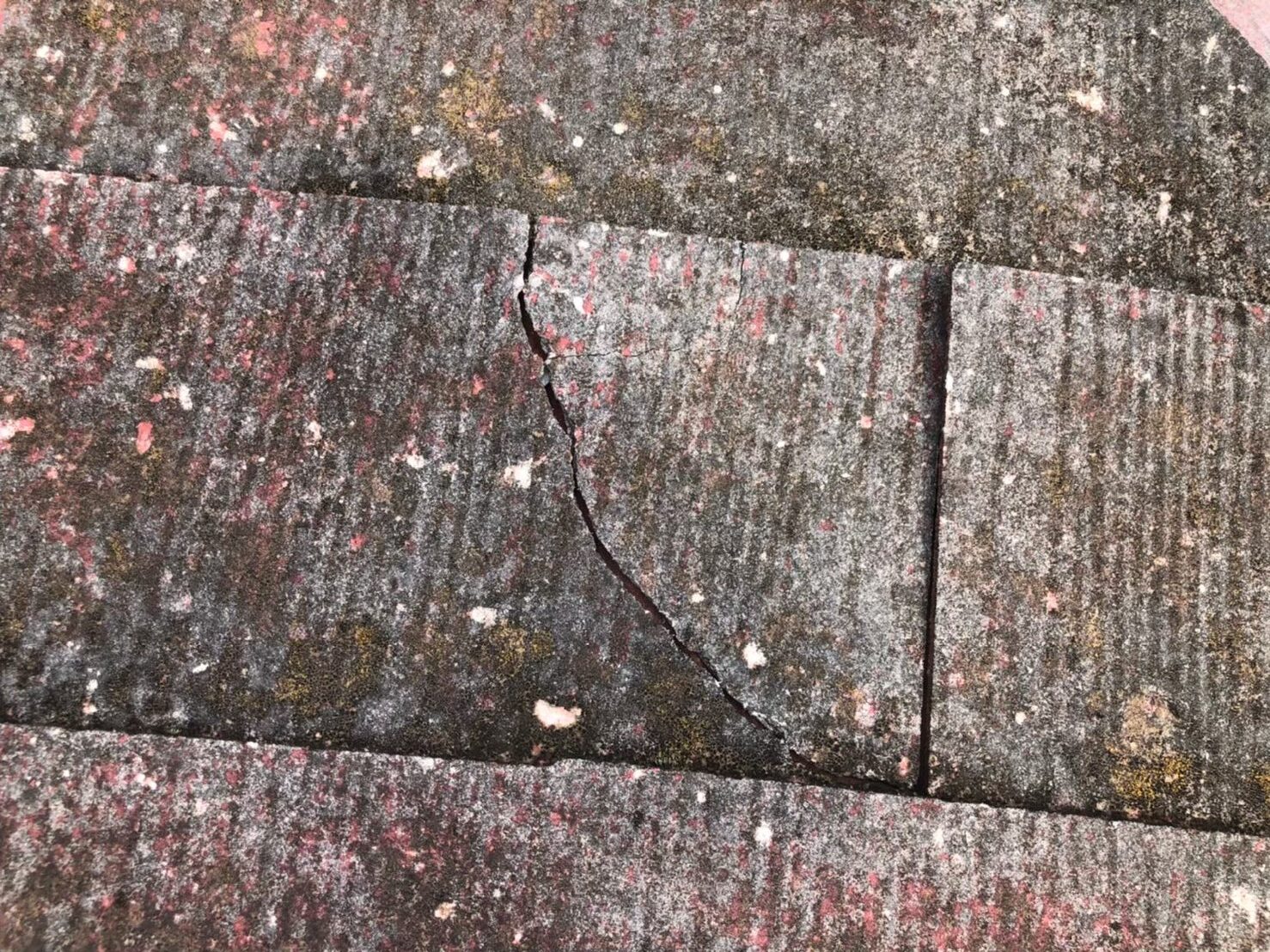 台風の影響によりスレート屋根にひび割れが生じた状態