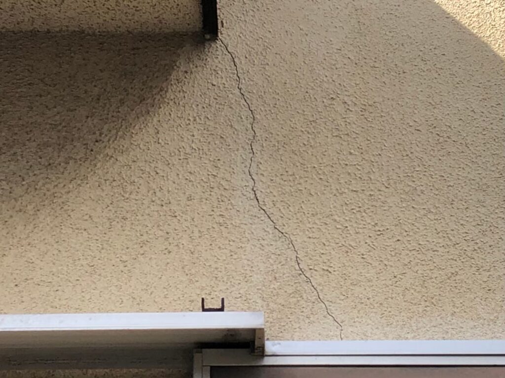 地震の影響により外壁表面がひび割れしている状態