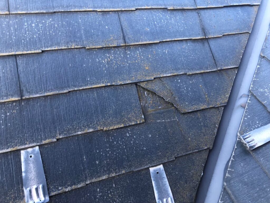 台風の影響によりスレート屋根にひび割れが生じた状態