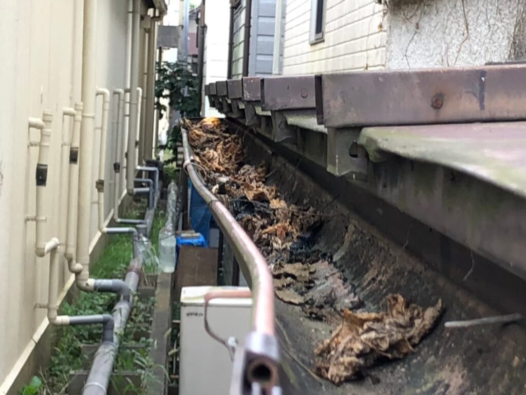 強風の影響により雨樋が大きく歪んでいる状態