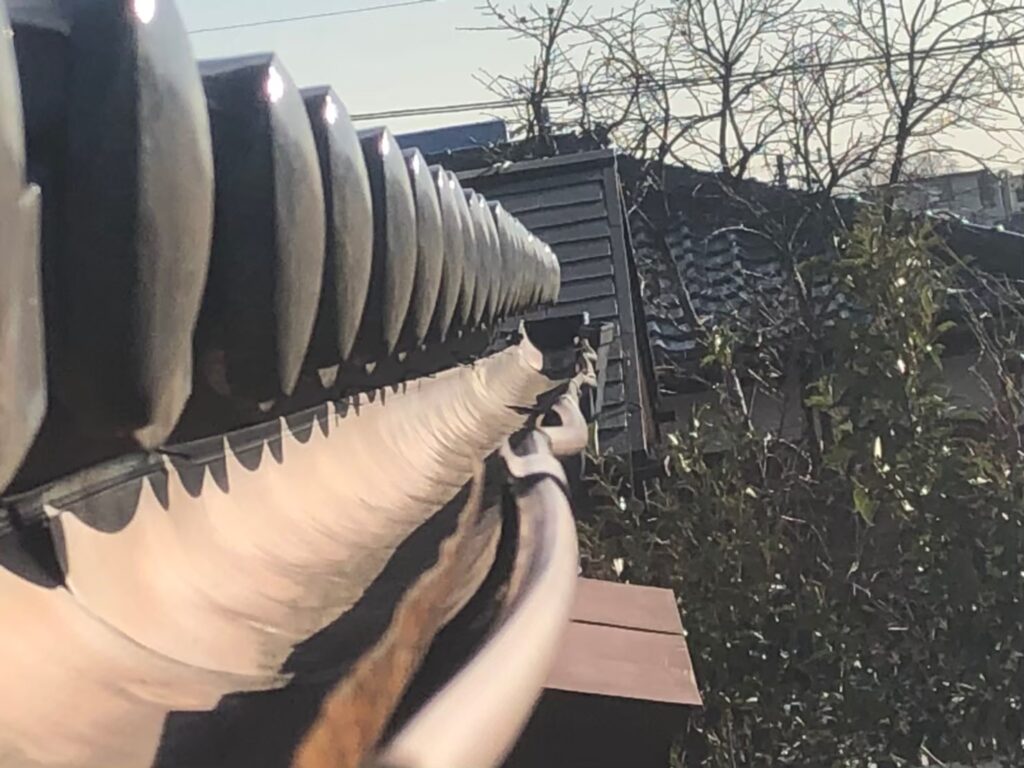 強風の影響により雨樋が大きく歪んでいる状態