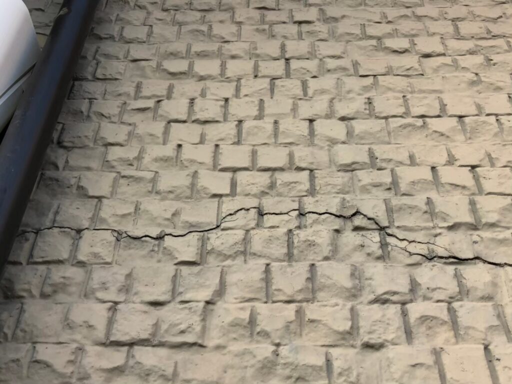 地震の影響により外壁表面がひび割れしている状態