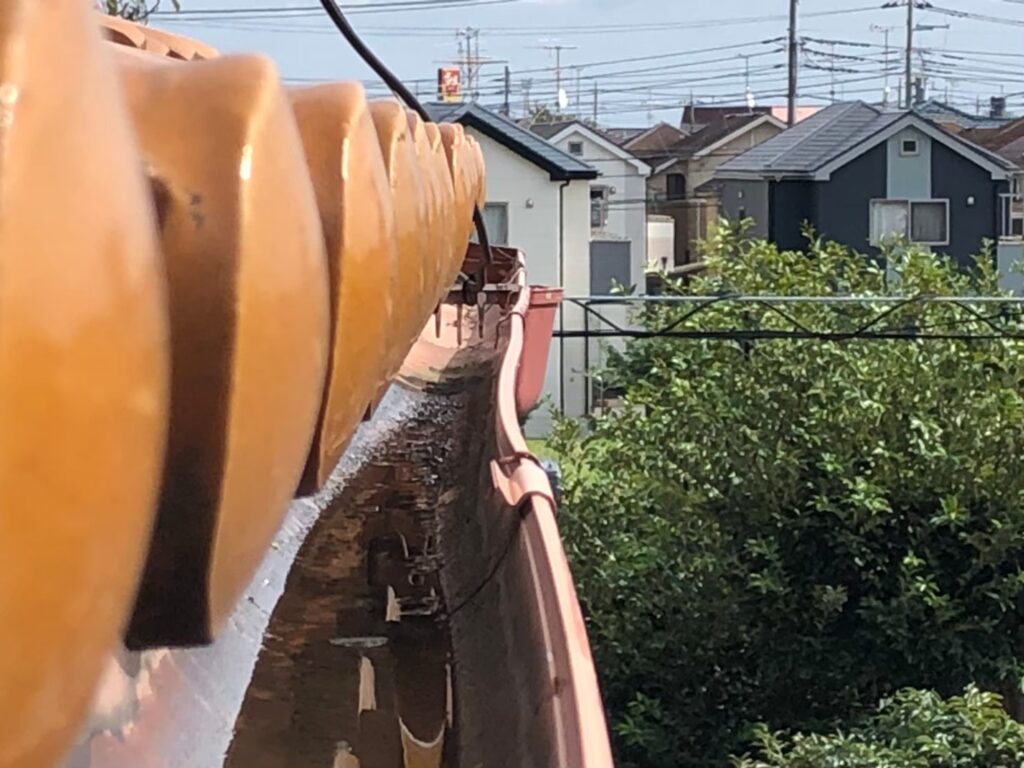 強風の影響により雨樋が大きく歪んでいる状態
