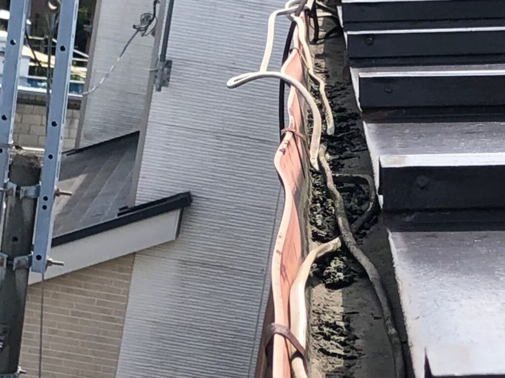 強風の影響により雨樋が大きく歪んでいる状態