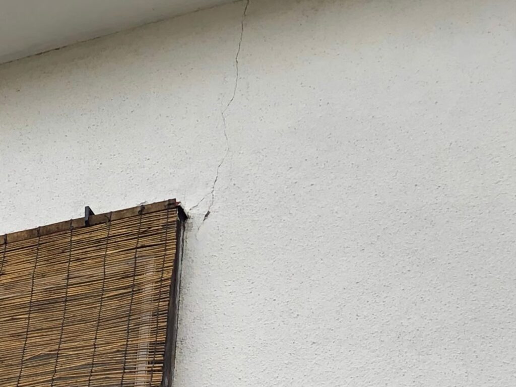 地震の影響により外壁表面がひび割れしている状態