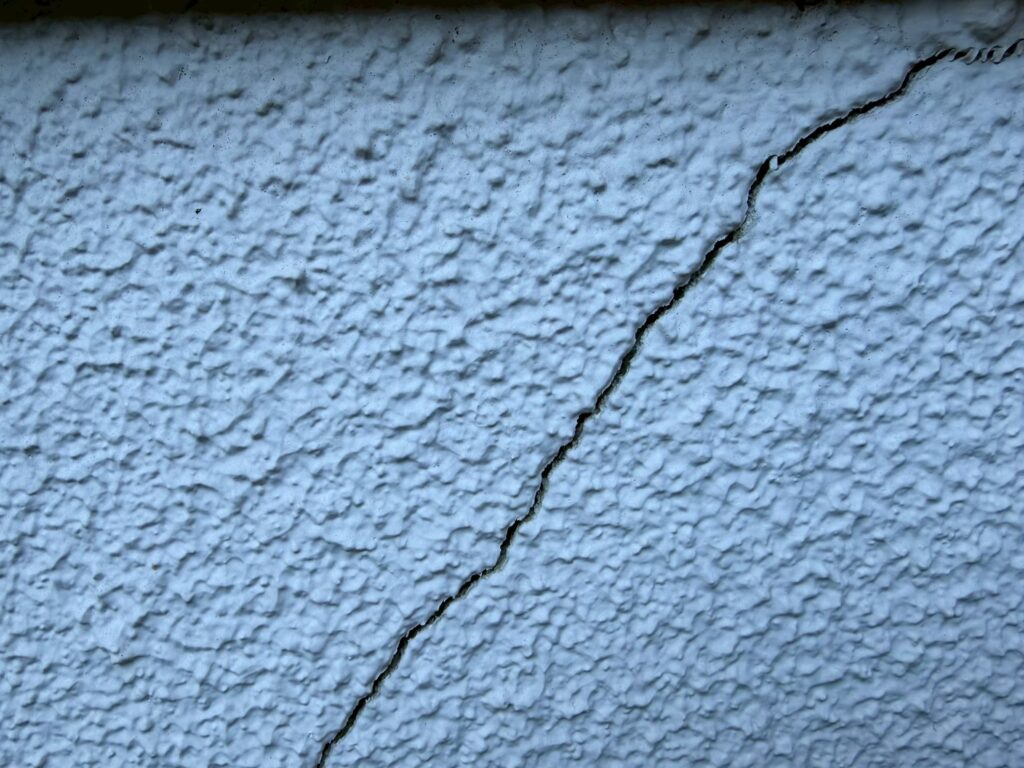 地震の影響により外壁表面がひび割れしている状態