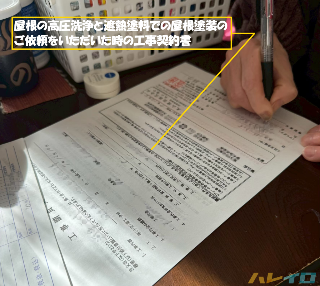 屋根の高圧洗浄と遮熱塗料による屋根の塗装工事のご契約書にサインをいただいているときの写真