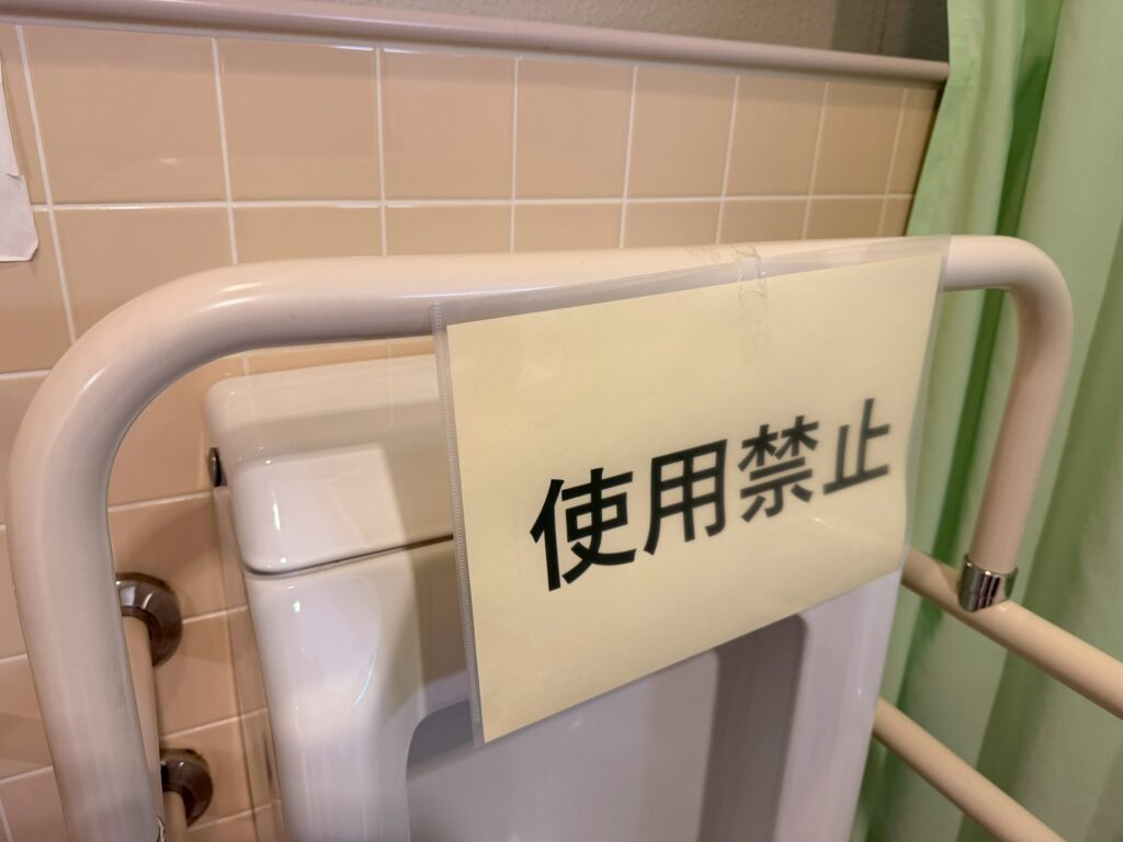 外来棟・療養病棟の男子トイレのセンサー機能が故障して、「使用禁止」と貼りだされた写真