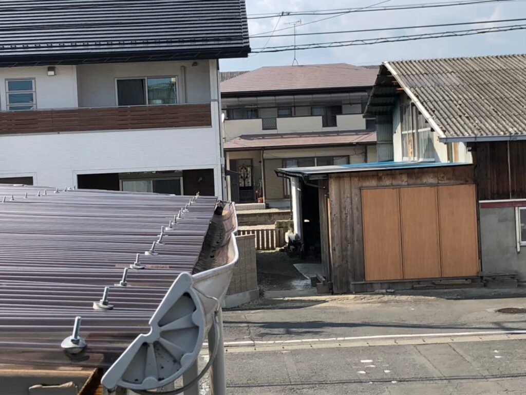 強風の影響により雨樋が大きく歪んでいる状態