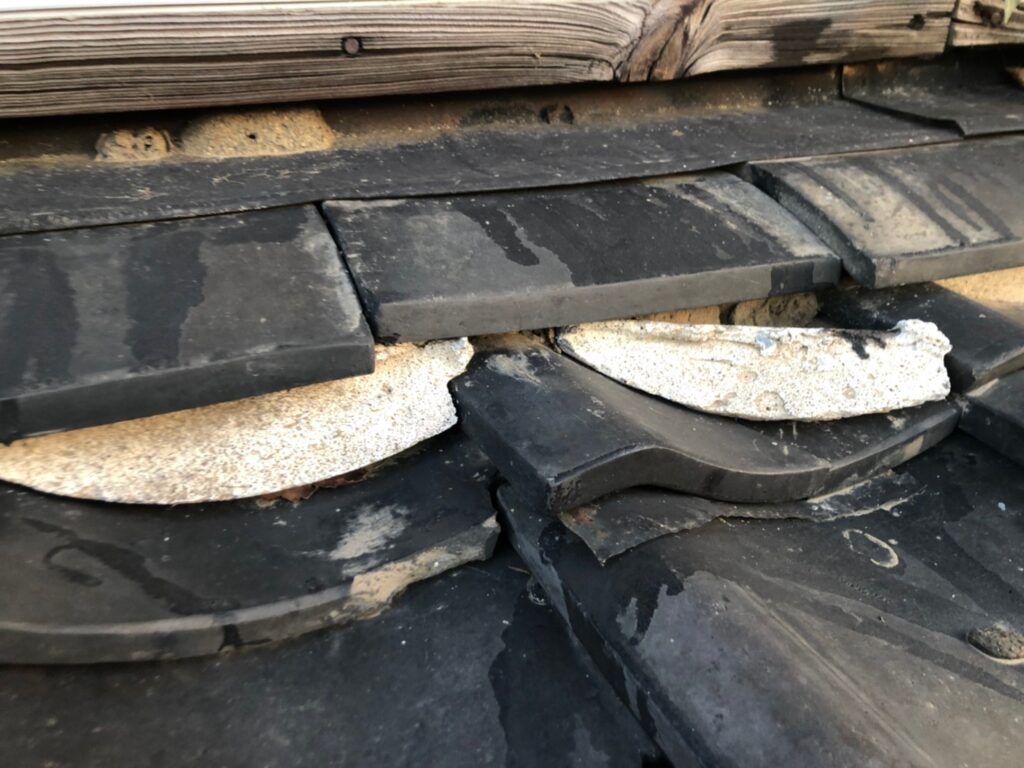 棟部分の漆喰が崩れて飛散し、内部が露出している状態