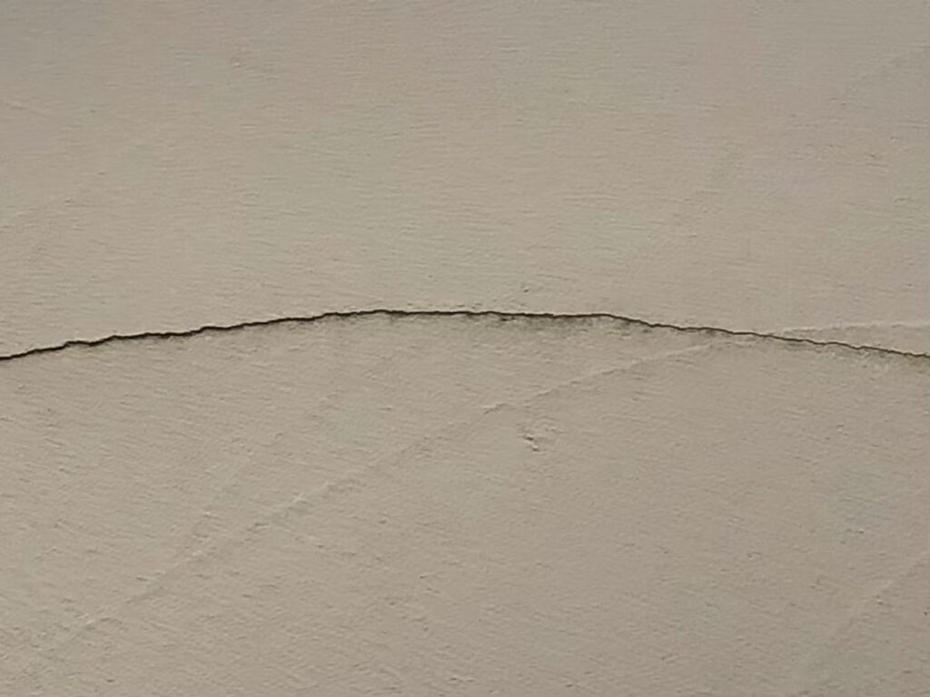 地震の影響により外壁表面がひび割れしている状態