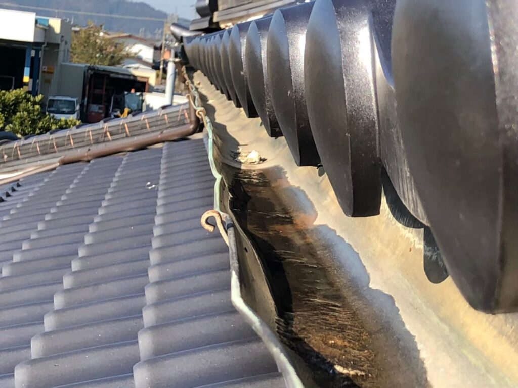 強風の影響により雨樋が大きく歪んでいる状態