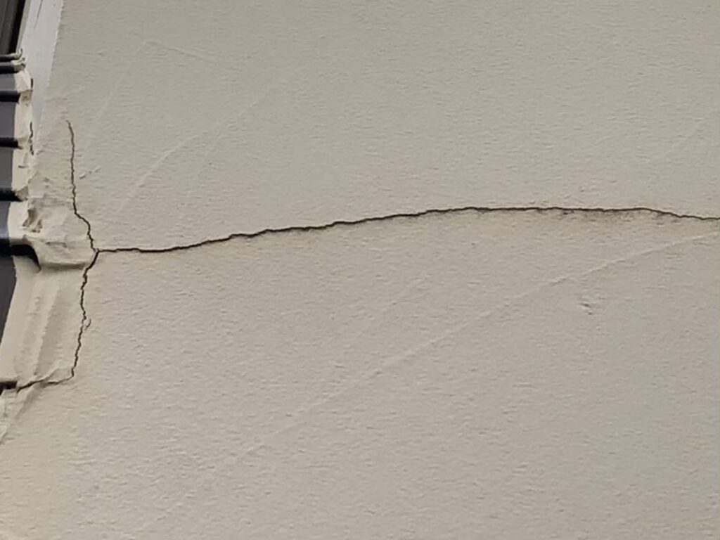 地震の影響により外壁表面がひび割れしている状態