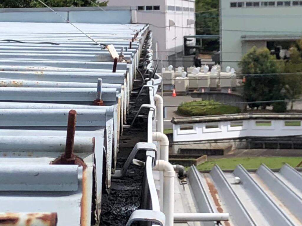 強風の影響により雨樋が大きく歪んでいる状態