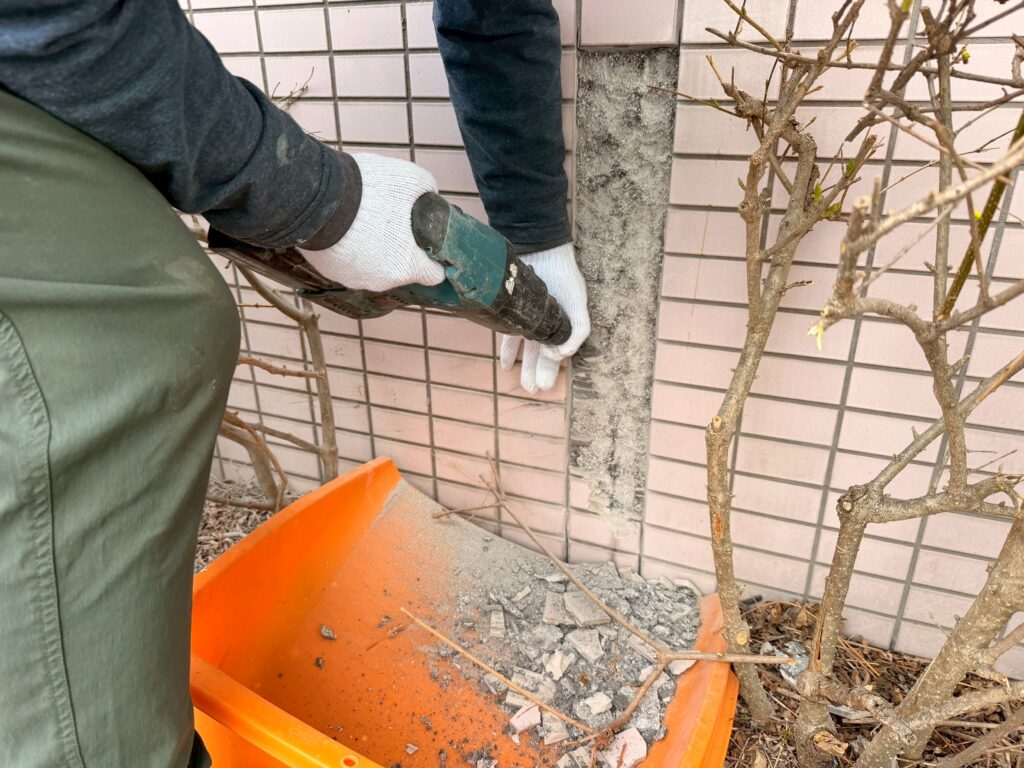 マキタ製のはつり機を使って、ひび割れた外壁タイル14枚を撤去している写真