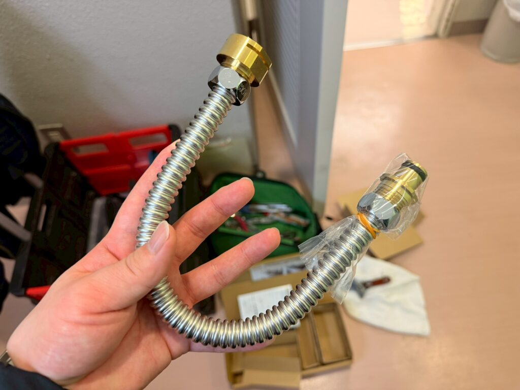 電磁弁の給水から排水へ接続する新品のフレキシブル菅の写真