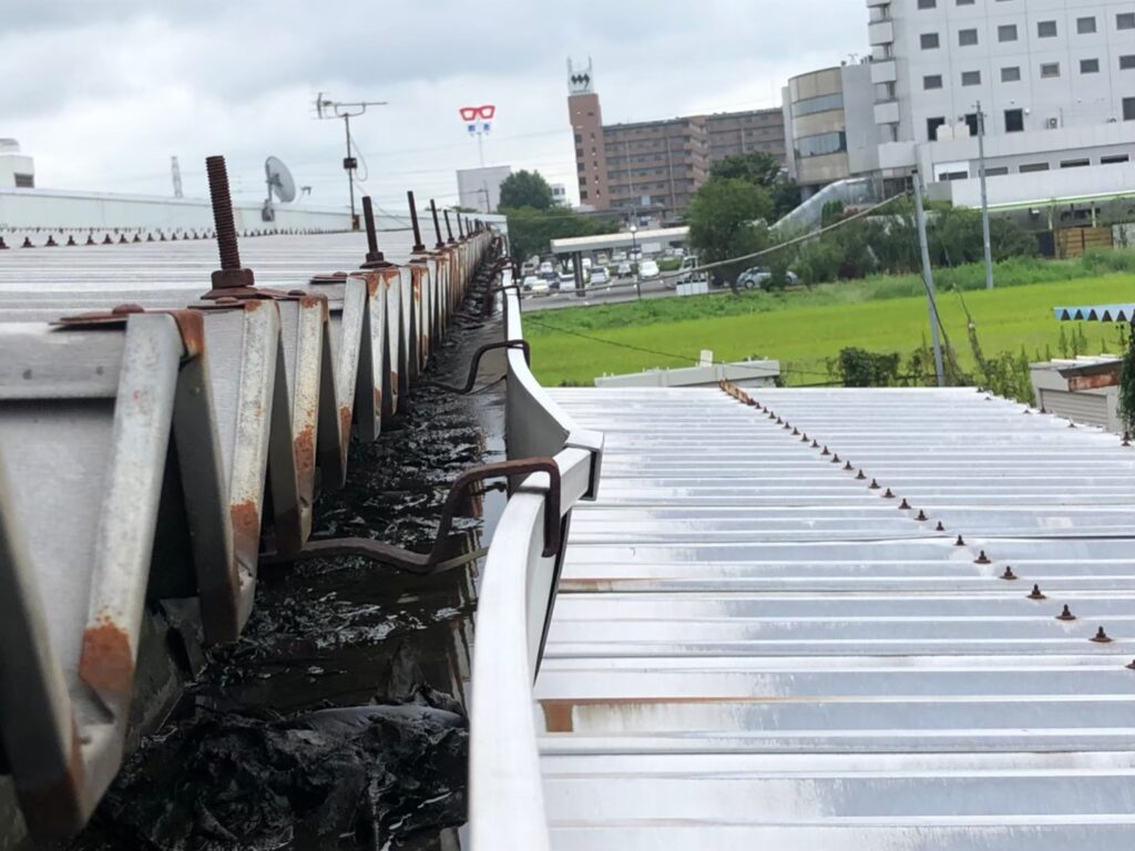 強風の影響により雨樋が大きく歪んでいる状態