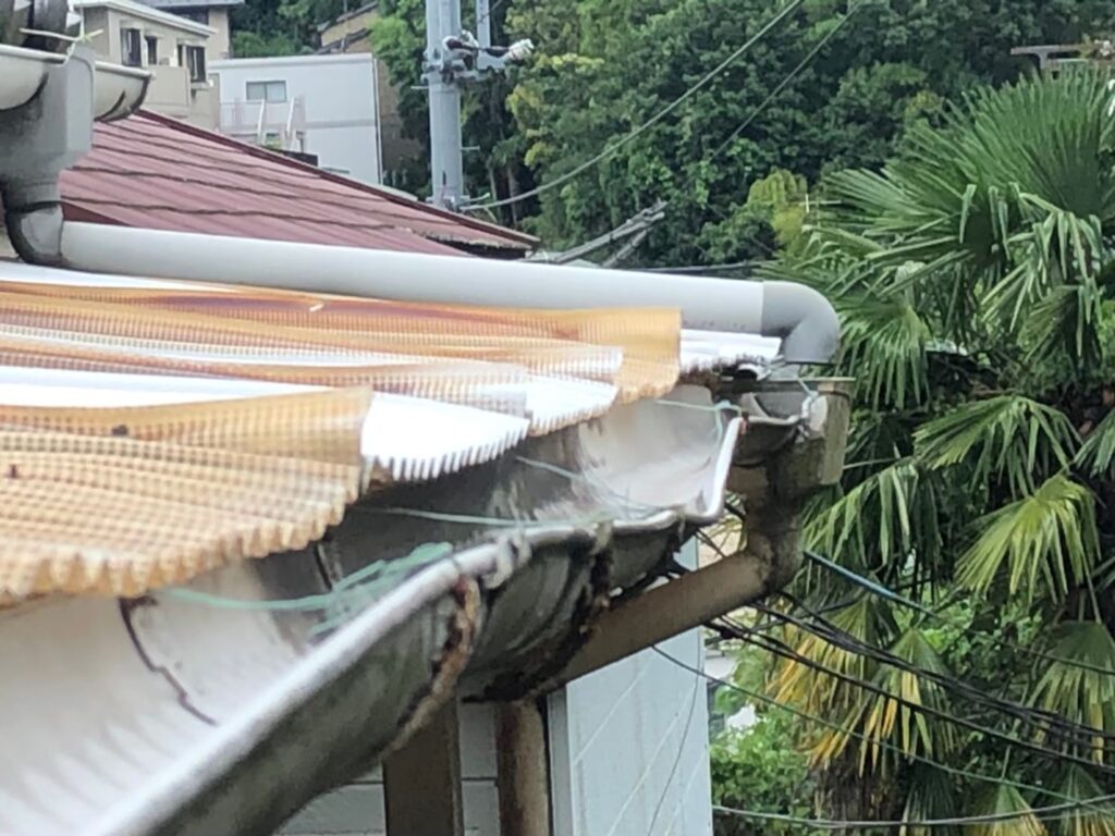 強風の影響により雨樋が大きく歪んでいる状態
