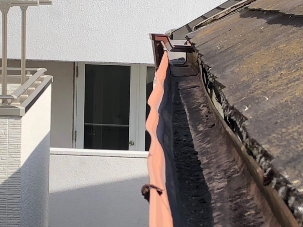 強風の影響により雨樋が大きく歪んでいる状態