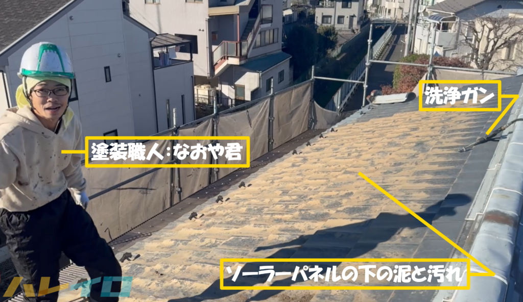 塗装職人のなおや君と、ソーラーパネルの下の泥や汚れと高圧洗浄機の先端のガンが映っている写真