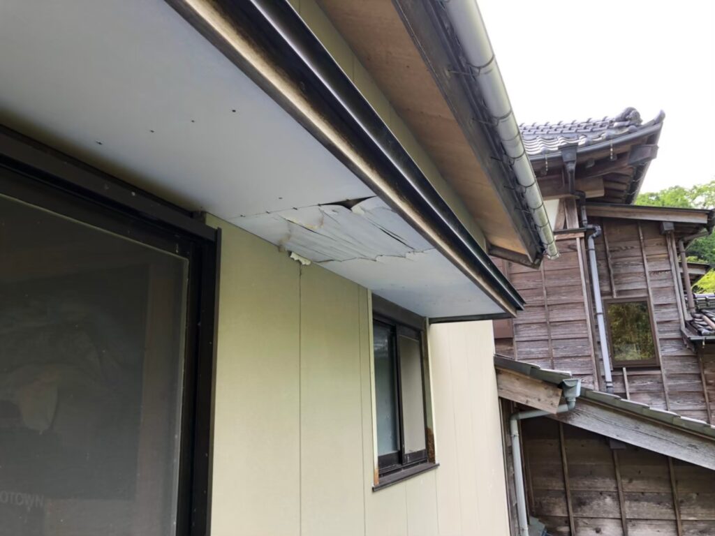 湿気や雨水の影響で軒天が腐食し、剥がれが発生している状態