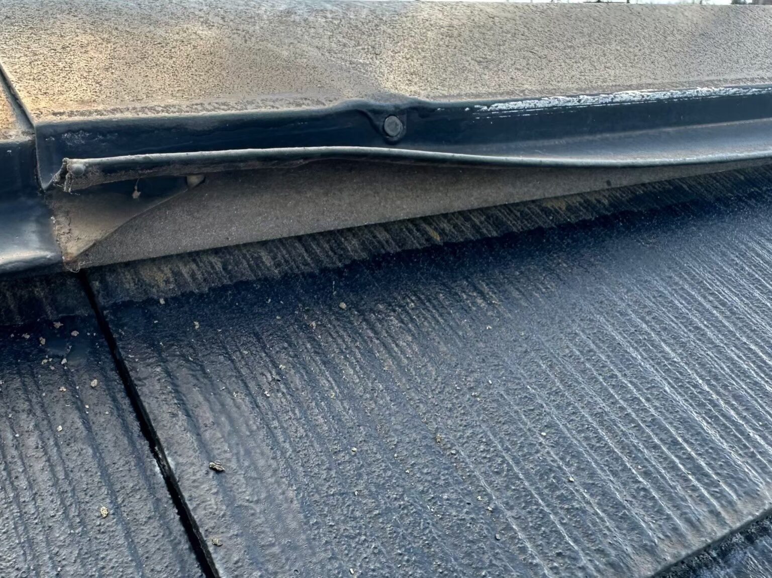 棟板金が浮き上がり、屋根材との間に隙間ができている様子