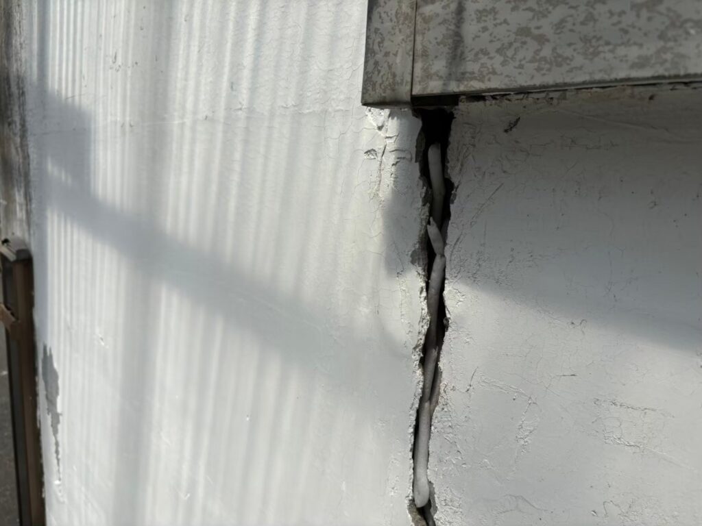 大きなひび割れが生じ雨水が侵入しやすい外壁の劣化状態