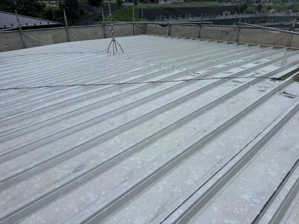 屋根塗装工事の現場で実際に撮影した施工前のガルバリウム鋼板屋根の色褪せの作業写真