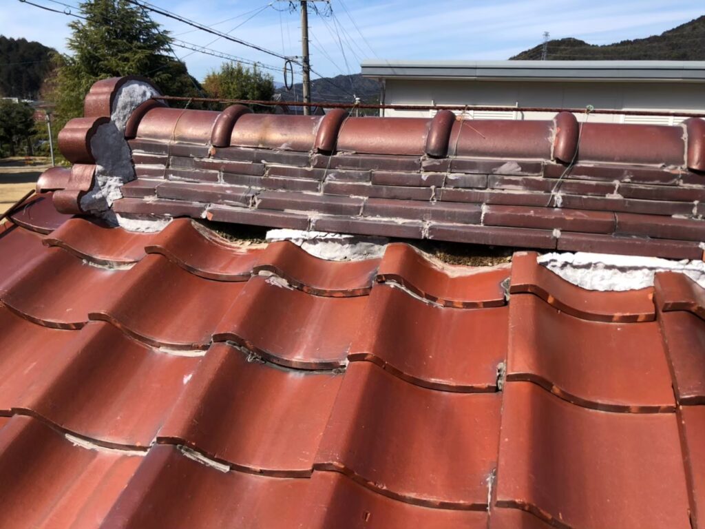 棟の漆喰が崩れて内部が露出した瓦屋根の破損状態