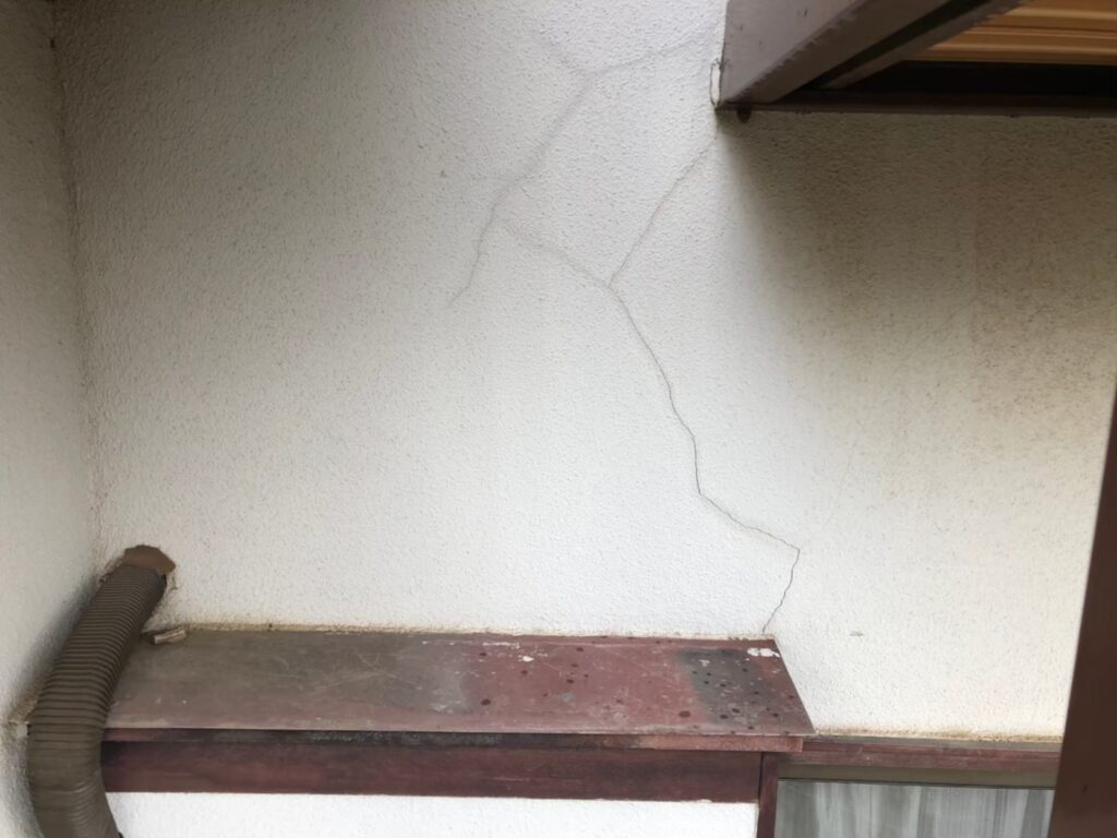 大きなひび割れが生じ雨水が侵入しやすい外壁の劣化状態