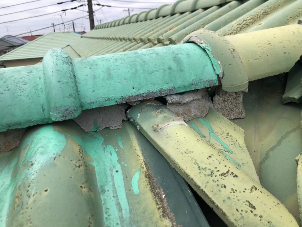 棟の漆喰が崩れて内部が露出した瓦屋根の破損状態